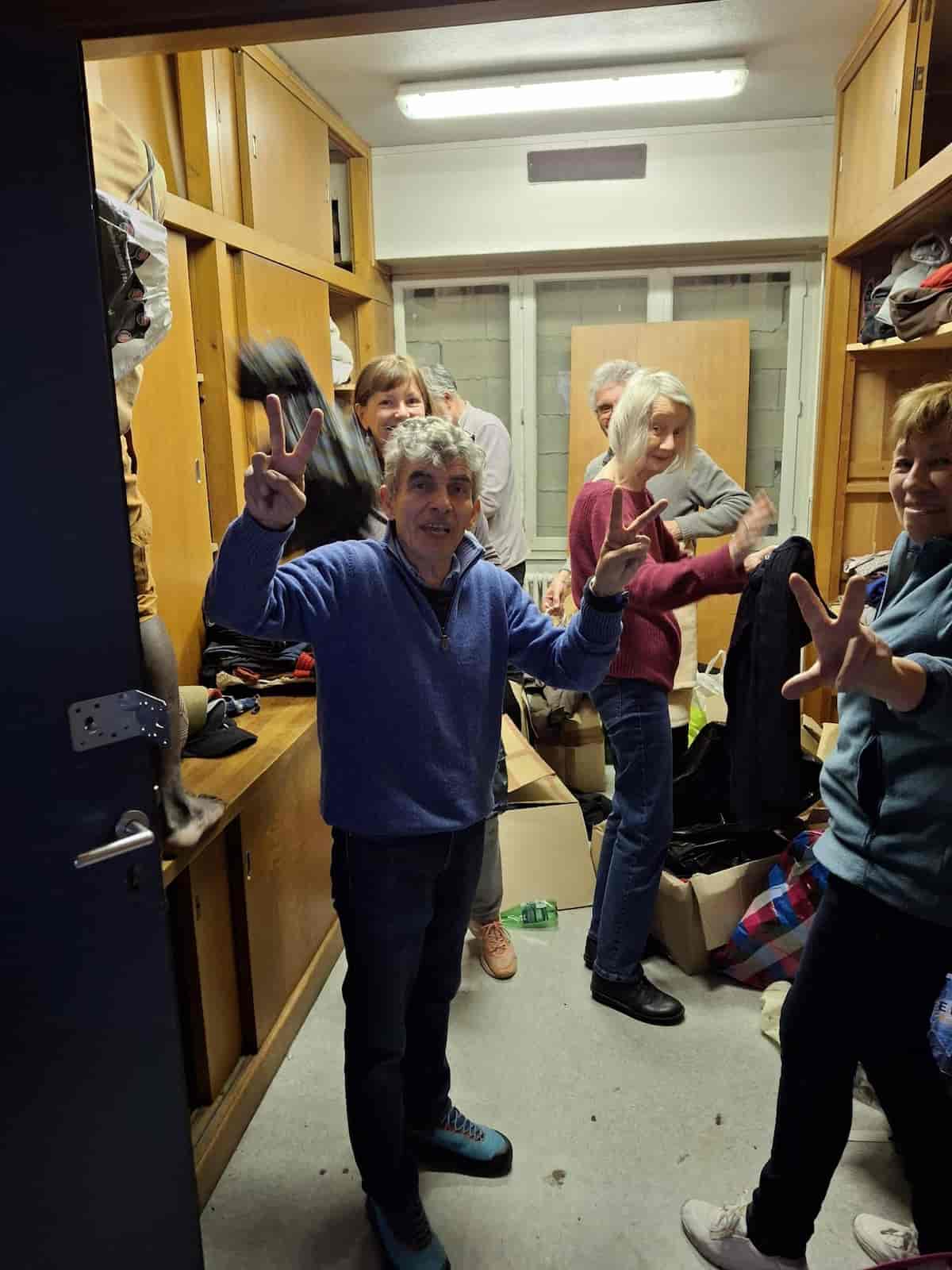 Bénévoles de TEC 31 entrain de ranger des vêtements dans un vestiaire.