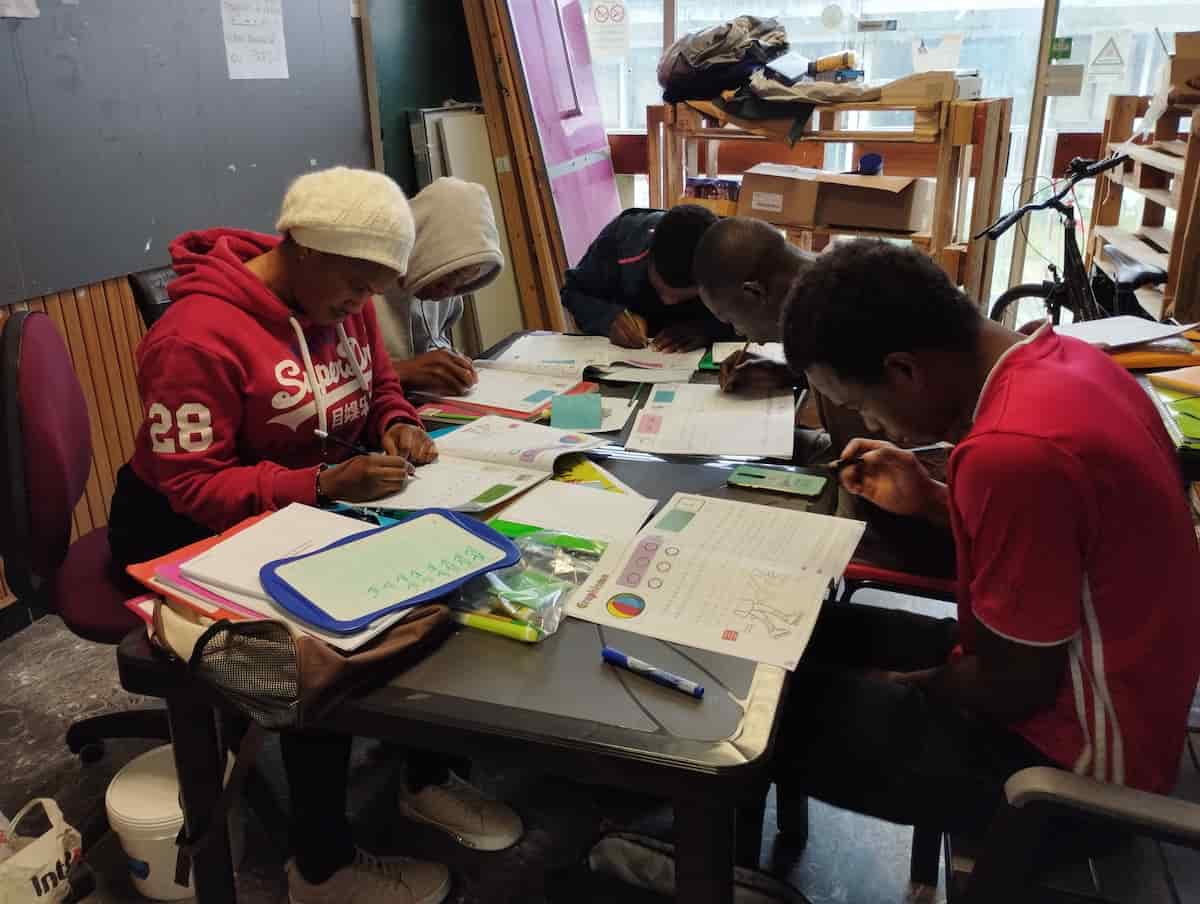 jeunes mineurs isolés étrangers en train d'étudier en classe.