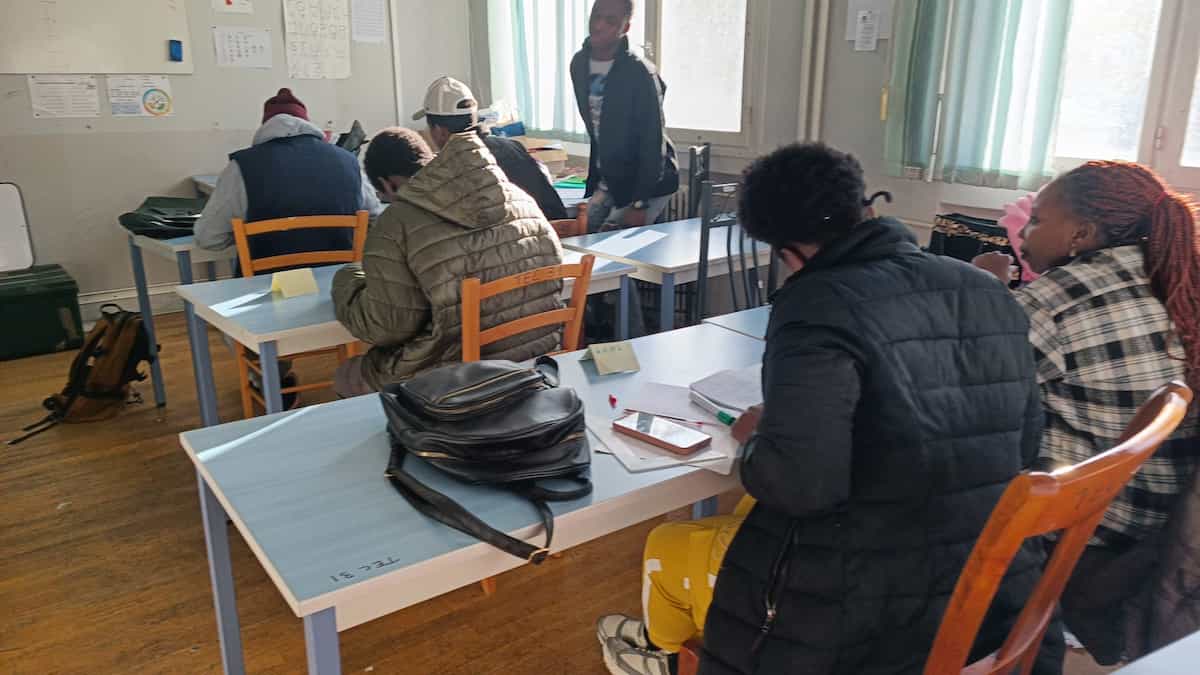 jeunes mineurs étrangers en train d'étudier en classe.